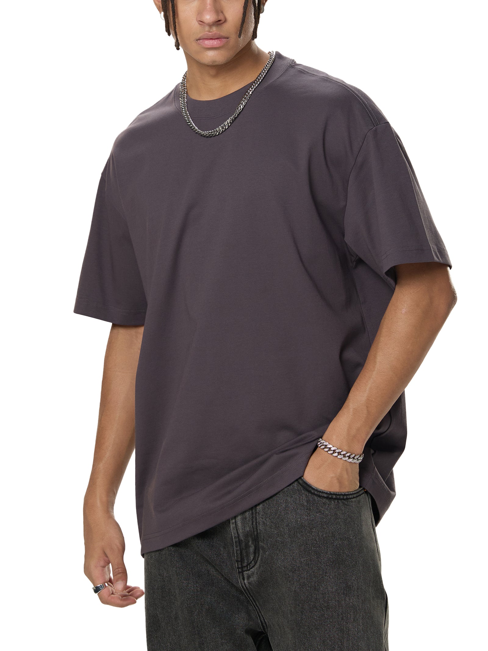 T-shirt oversized Sorona porté de trois quarts par un mannequin homme, tombé fluide sur jean gris