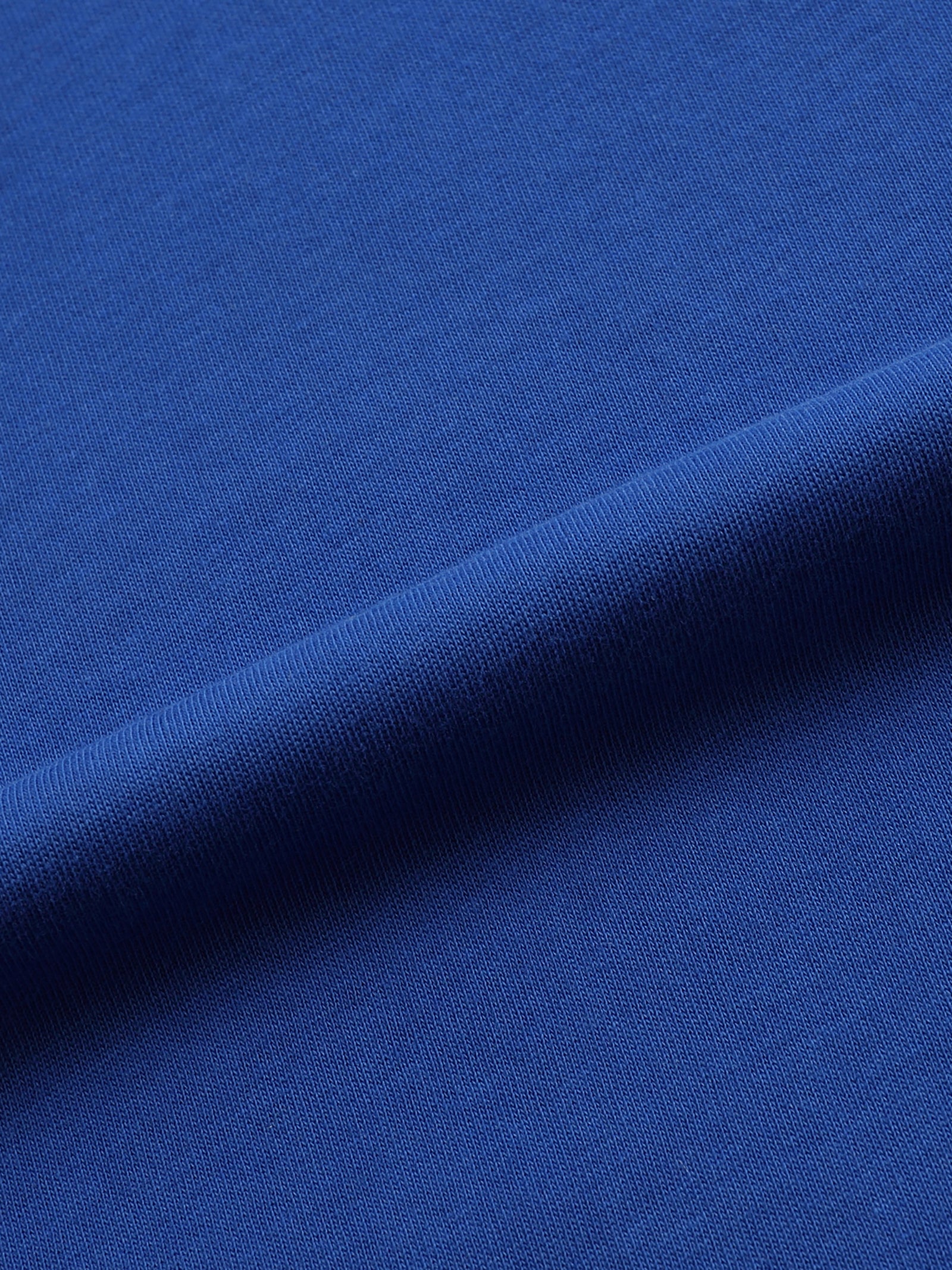 Macro du coton bleu vif du t-shirt - maille dense de 220 g par mètre carré