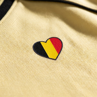 Macro du cœur drapeau belge noir jaune rouge imprimé sur la maille piquée du maillot foot belge femme original