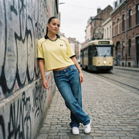 Maillot foot belge femme original en look streetwear dans une rue de Bruxelles avec tram et jean baggy