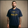 Homme buzz cut et tatouages portant le maillot de foot streetwear oversize Wesh Pélo Heneni bleu marine – CHT'M