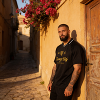 Maillot de foot streetwear oversize Zwanze City noir porté par un homme dans une ruelle méditerranéenne