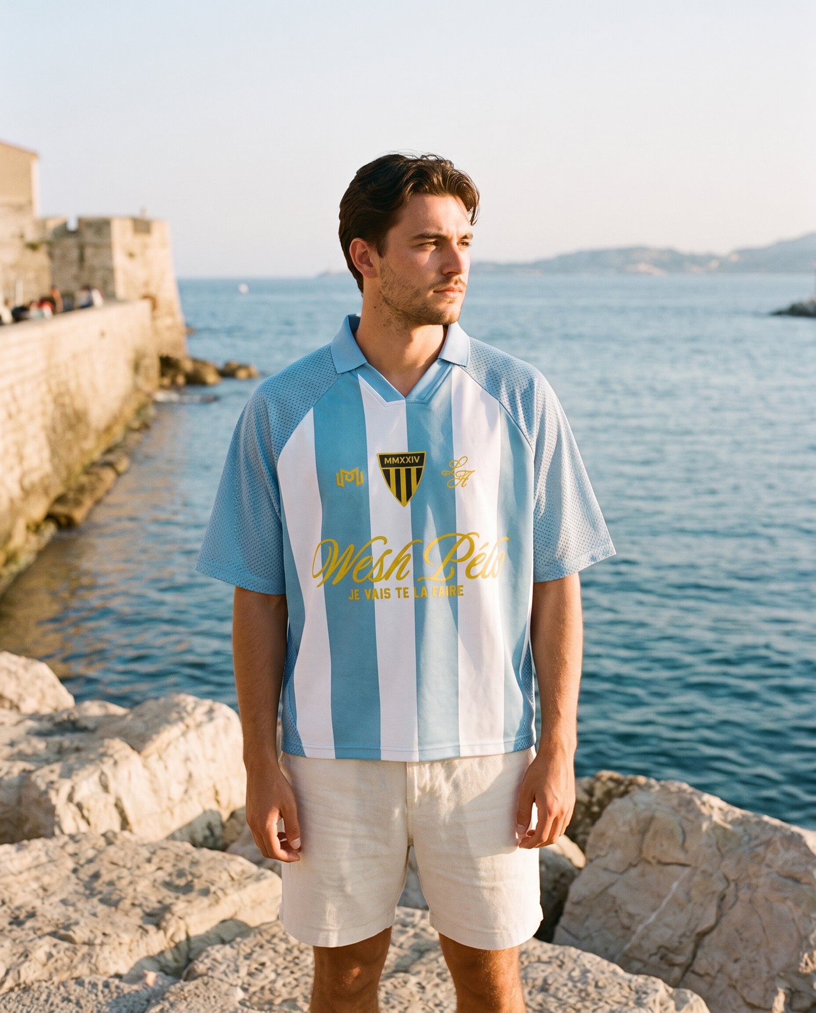 Homme portant le maillot de foot Wesh Pélo Bleu Ciel & Blanc au bord de mer méditerranéen