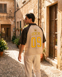 Dos du maillot de foot Wesh Pélo Café Abricot avec floquage doré HENENI 09, porté dans une ruelle méditerranéenne