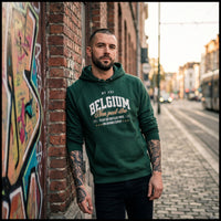 Pull belge original Non Peut-Être en look streetwear dans une rue pavée de Bruxelles