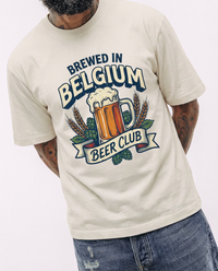 Homme portant le t-shirt oversized Brewed in Belgium en beige sable, bandeau Beer Club visible