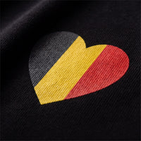 Gros plan sur le coeur noir jaune rouge imprime sur le coton lourd noir d'un t-shirt belge