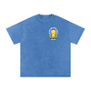 T-shirt belge original Né sous une drache d'amour vu de face, badge imprimé discret sur la poitrine, coton bleu délavé