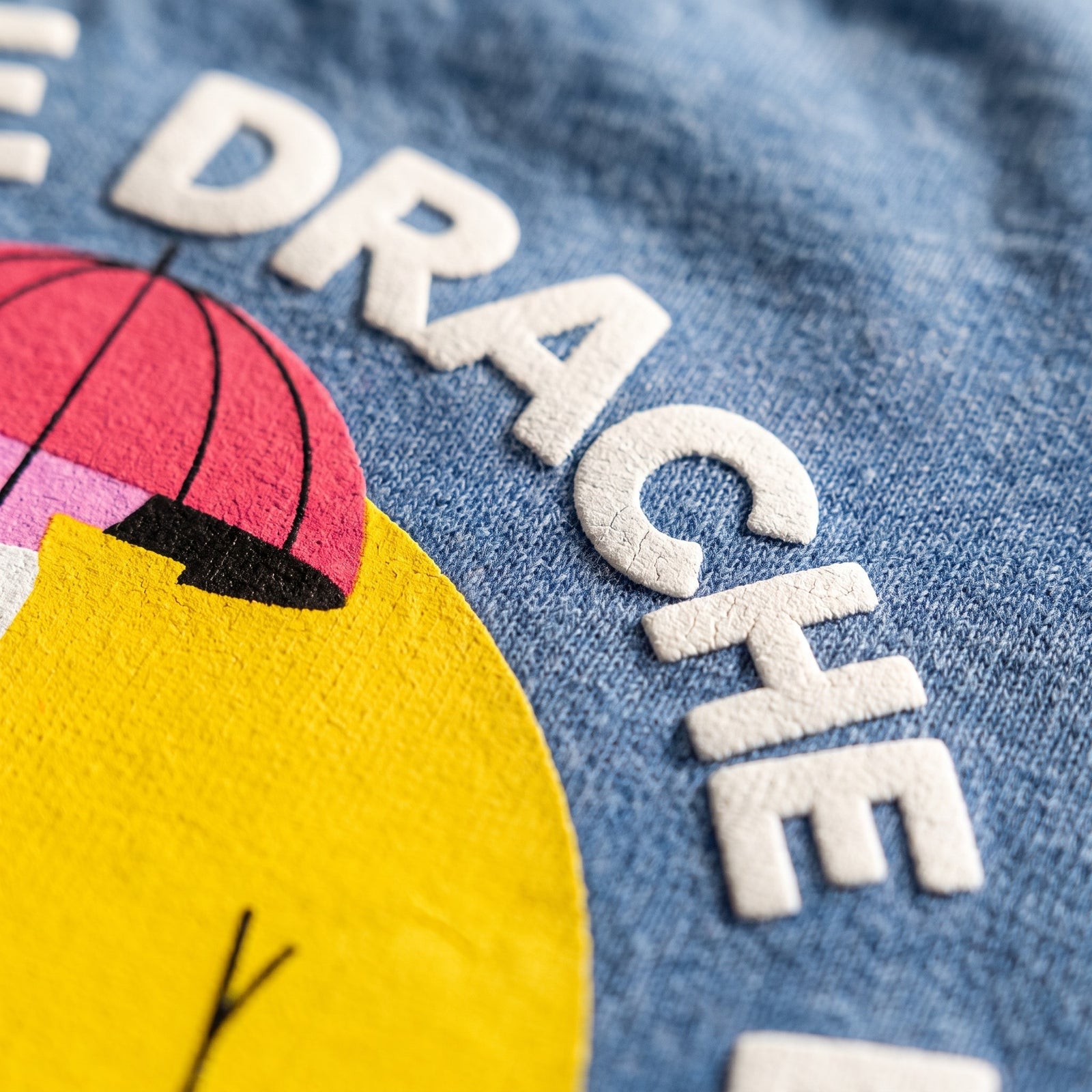 Macro de la sérigraphie du t-shirt belge drache d'amour - lettrage DRACHE et parapluie rose sur coton