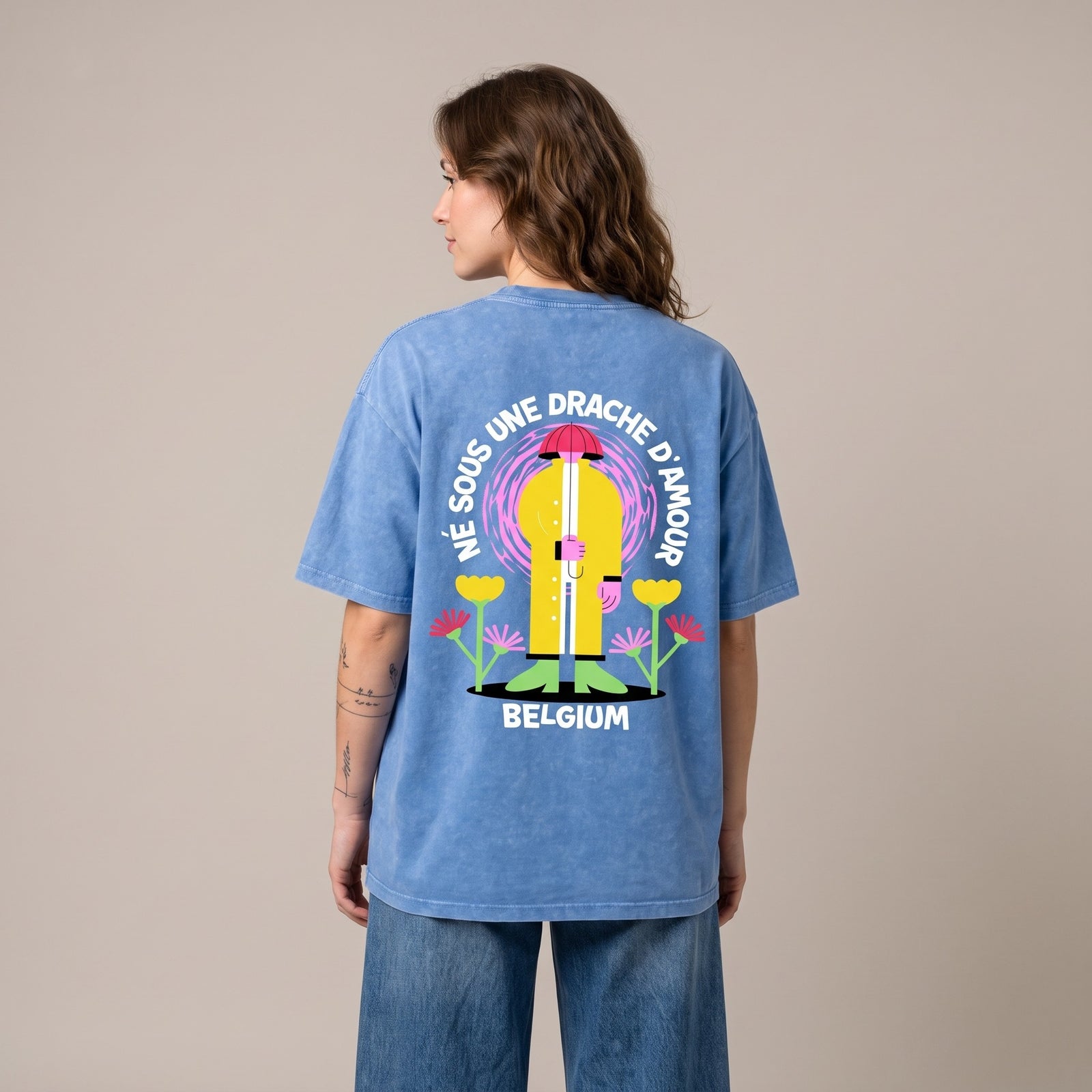 Femme de dos en studio portant le t-shirt belge oversized Né sous une drache d'amour bleu délavé