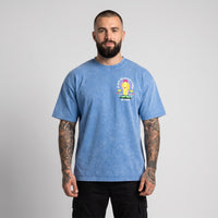 Homme barbu et tatoué en studio portant de face le t-shirt belge oversized bleu délavé drache d'amour
