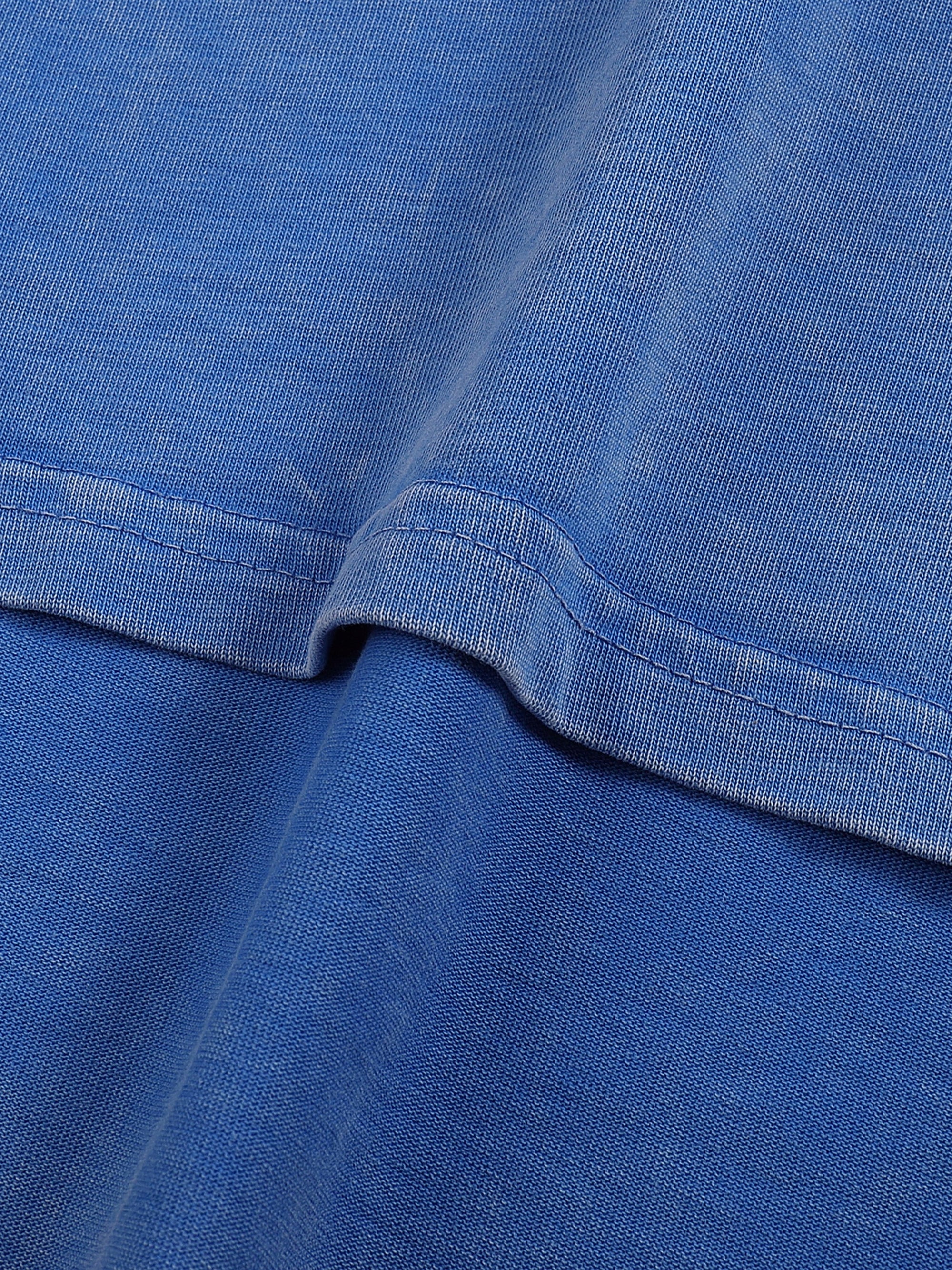 Texture du coton délavé bleu du t-shirt belge original Né sous une drache d'amour