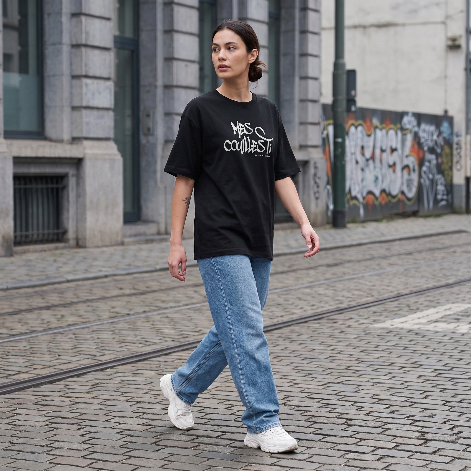 T-shirt expression bruxelloise Mes Couilles Ti porté par une femme en rue - streetwear belge oversize