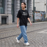 T-shirt expression bruxelloise Mes Couilles Ti porté par une femme en rue - streetwear belge oversize
