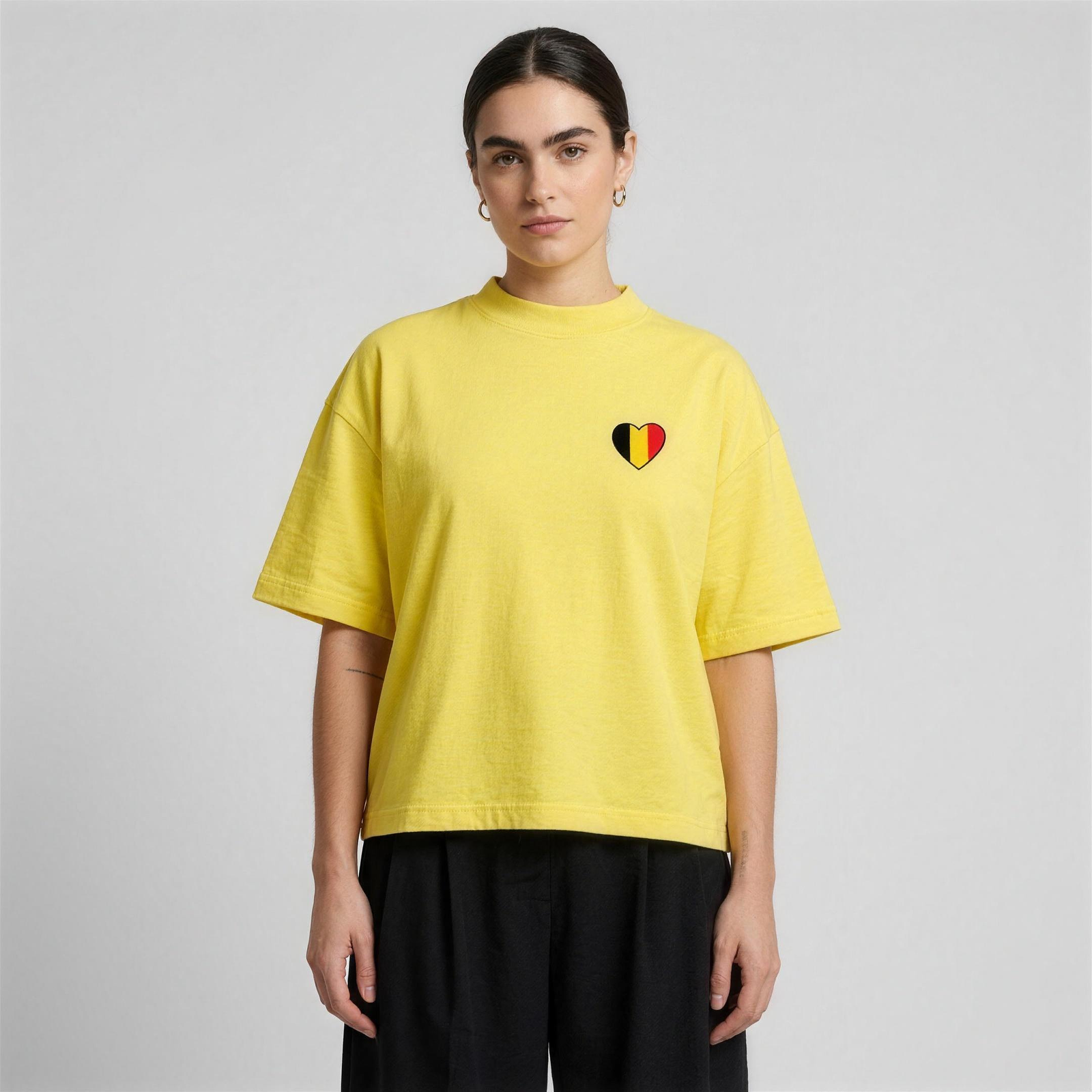 T-shirt belge oversized jaune porté par une femme, coupe boxy unisexe et cœur tricolore