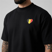 Zoom sur le cœur drapeau belge imprimé sur la poitrine du t-shirt oversized noir
