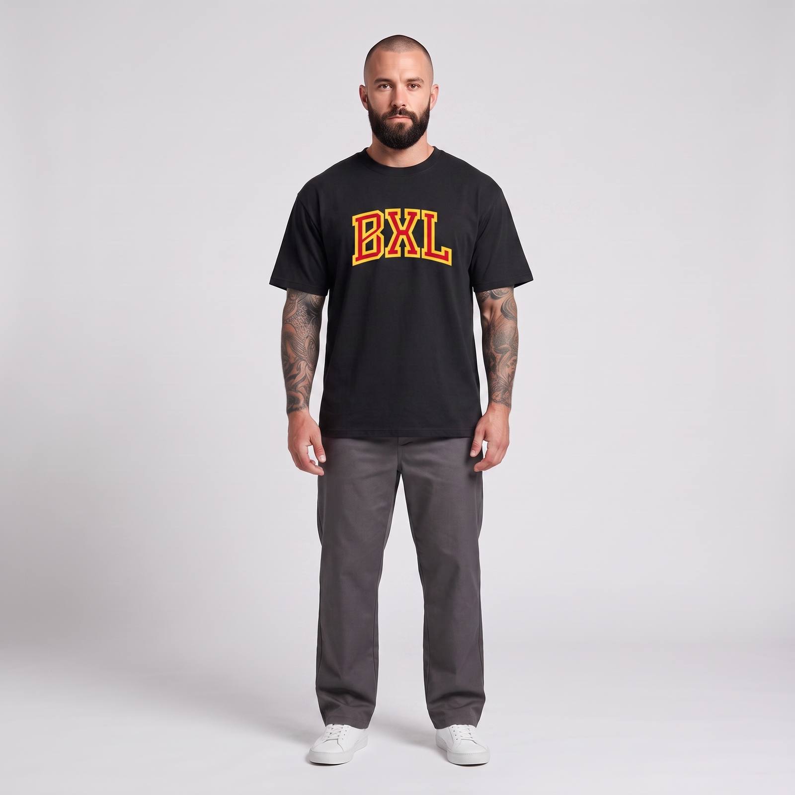 Homme barbu tatoué portant le t-shirt Bruxelles BXL oversize noir - photo studio