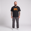 Homme barbu tatoué portant le t-shirt Bruxelles BXL oversize noir - photo studio