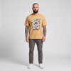 Homme barbu tatoué portant le t-shirt Cool Dad Club beige camel - photo studio