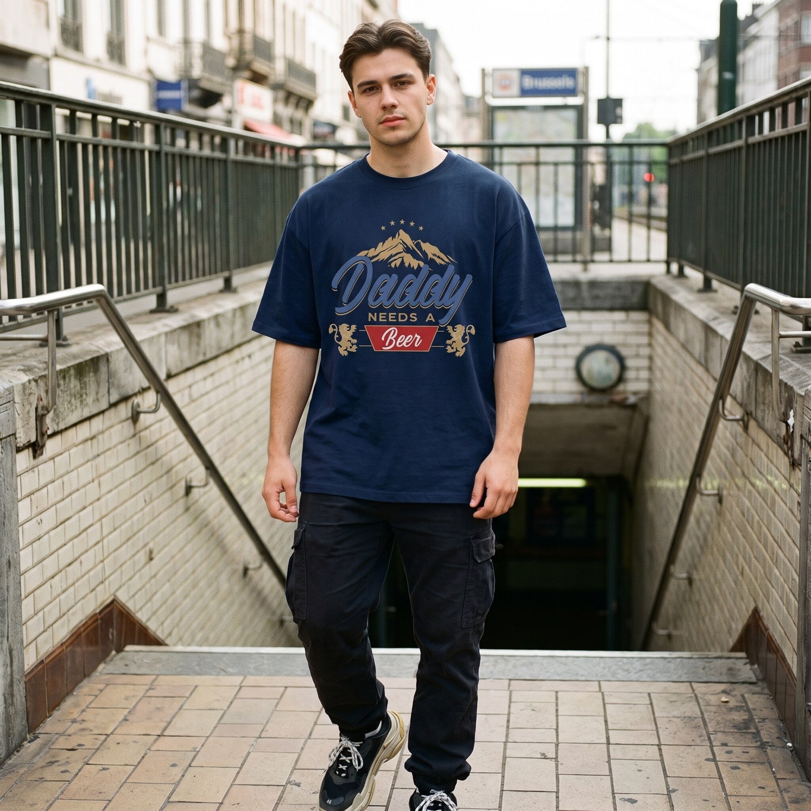 T-shirt oversized bleu marine Daddy Needs A Beer, blason doré aux lions, porté en haut d'un escalier de métro