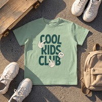 T-shirt enfant Cool Kids Club vert sauge en flat-lay streetwear avec skateboard et sneakers