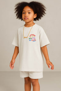 T-shirt enfant oversized écru porté de face - petit imprimé coloré sur le cœur