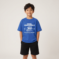 Garçon en t-shirt enfant oversized Cool Crocodile bleu vif, studio fond clair, coupe ample