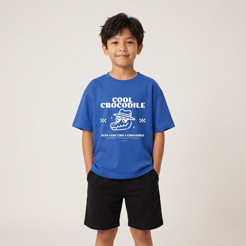 Garçon en t-shirt enfant oversized Cool Crocodile bleu vif, studio fond clair, coupe ample