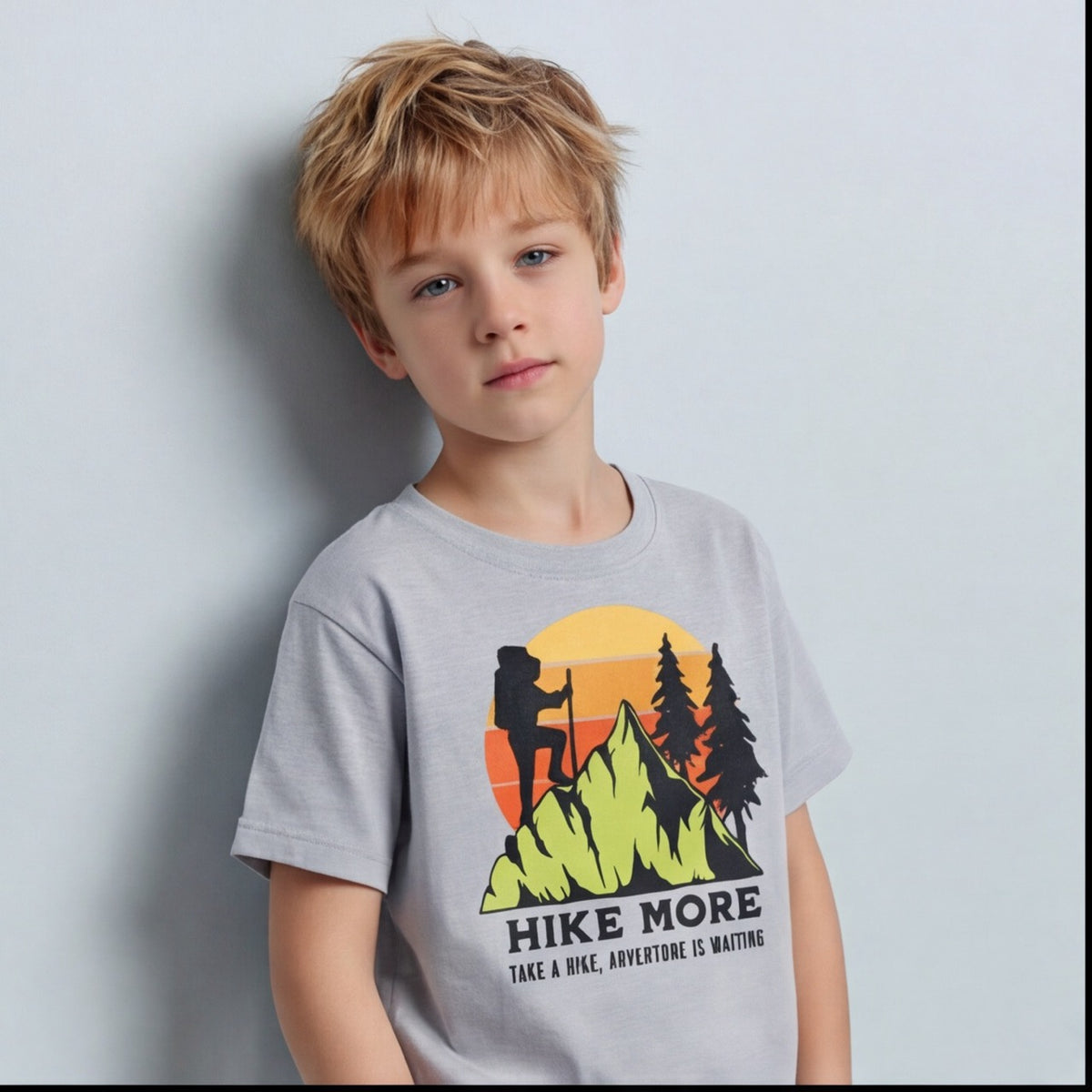 T-shirt enfant Hike More gris clair vu de face en buste, montagne verte et sapins noirs