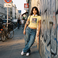 T-shirt anime femme porté en rue devant un mur graffé – look streetwear urbain