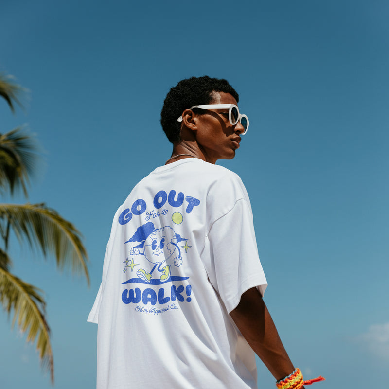 Homme de dos portant le t-shirt oversized blanc Go Out For a Walk, imprimé globe cartoon bleu