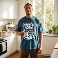 T-shirt oversized bleu petrole ma femme connait tout, porte dans une cuisine lumineuse un mug de cafe a la main