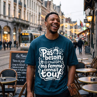 T-shirt humour bleu petrole ChatGPT, porte en riant dans une rue commercante belge devant un tram et des terrasses
