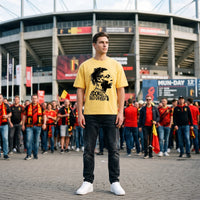 T-shirt oversized jaune imprimé Doku Red Devils, porté devant un stade au milieu des supporters des Diables Rouges