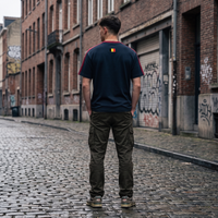 Homme streetwear portant le t-shirt Le Pays de la Bière bleu marine dans une rue belge - vue de dos drapeau belge, format carré