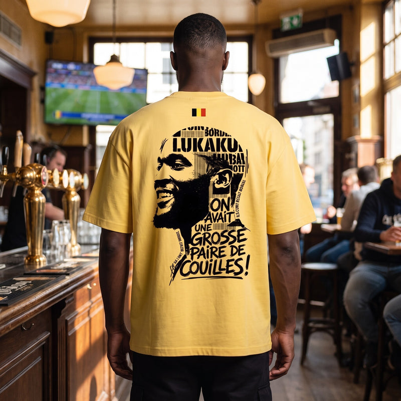 Vu de dos dans un estaminet belge, le t-shirt jaune affiche le drapeau national et l'imprime Lukaku pleine largeur