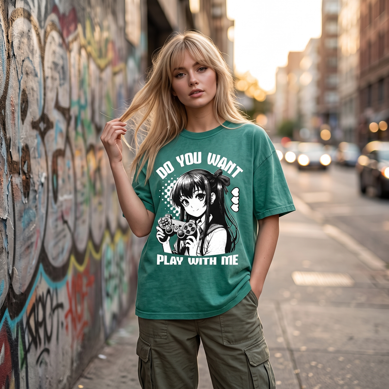 Femme en t-shirt oversized manga Gamer Girl vert délavé devant un mur graffé, allure streetwear