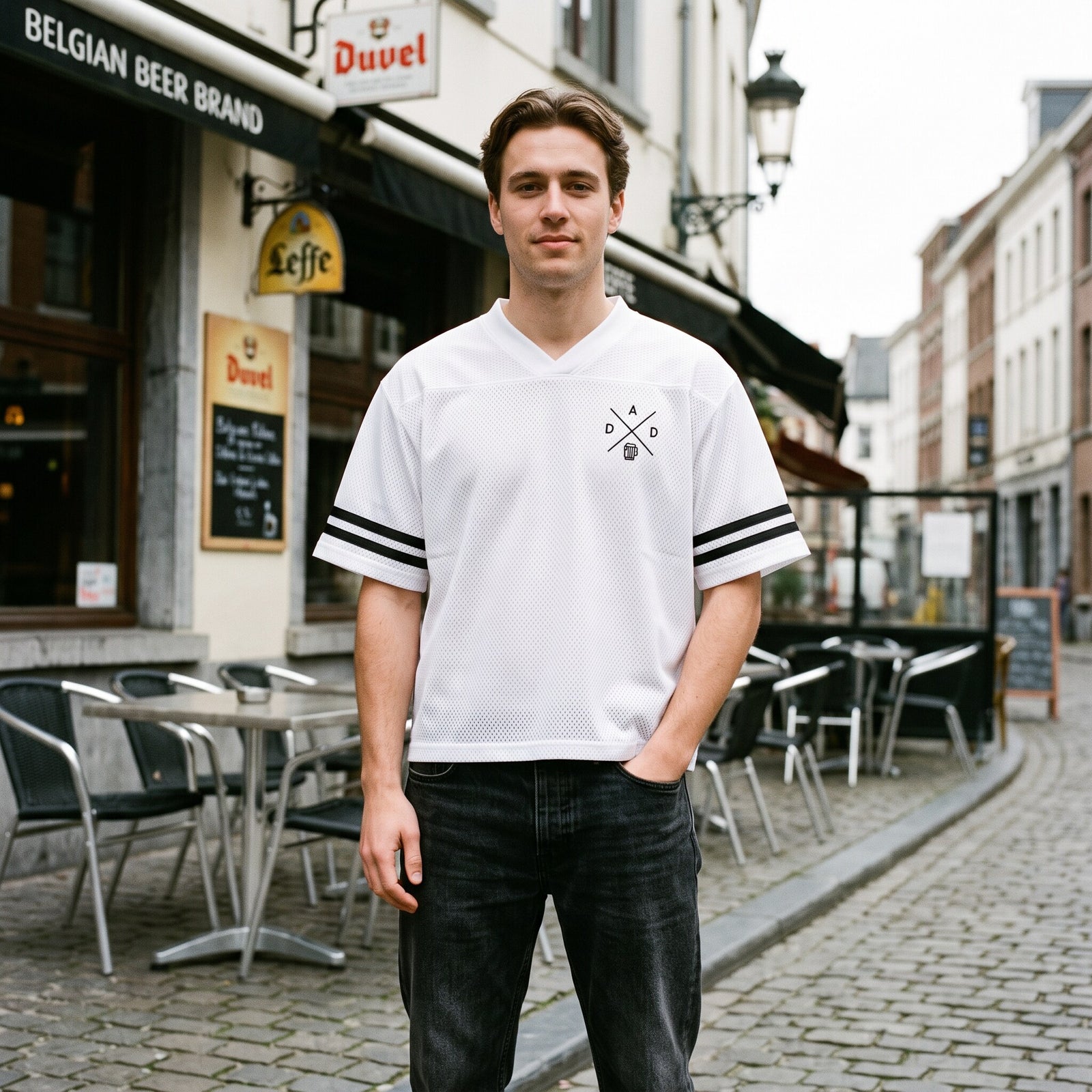 Maillot mesh blanc a col V et bandes noires, logo DAD a la chope, porte devant un cafe belge Duvel et Leffe