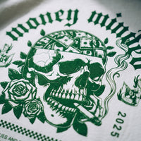 Gros plan sur l'impression verte du crane aux billets et aux roses Money Minded sur le coton blanc du t-shirt