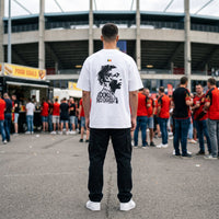 T-shirt oversized blanc vu de dos, portrait de Doku, porte devant un stade au milieu des supporters en rouge