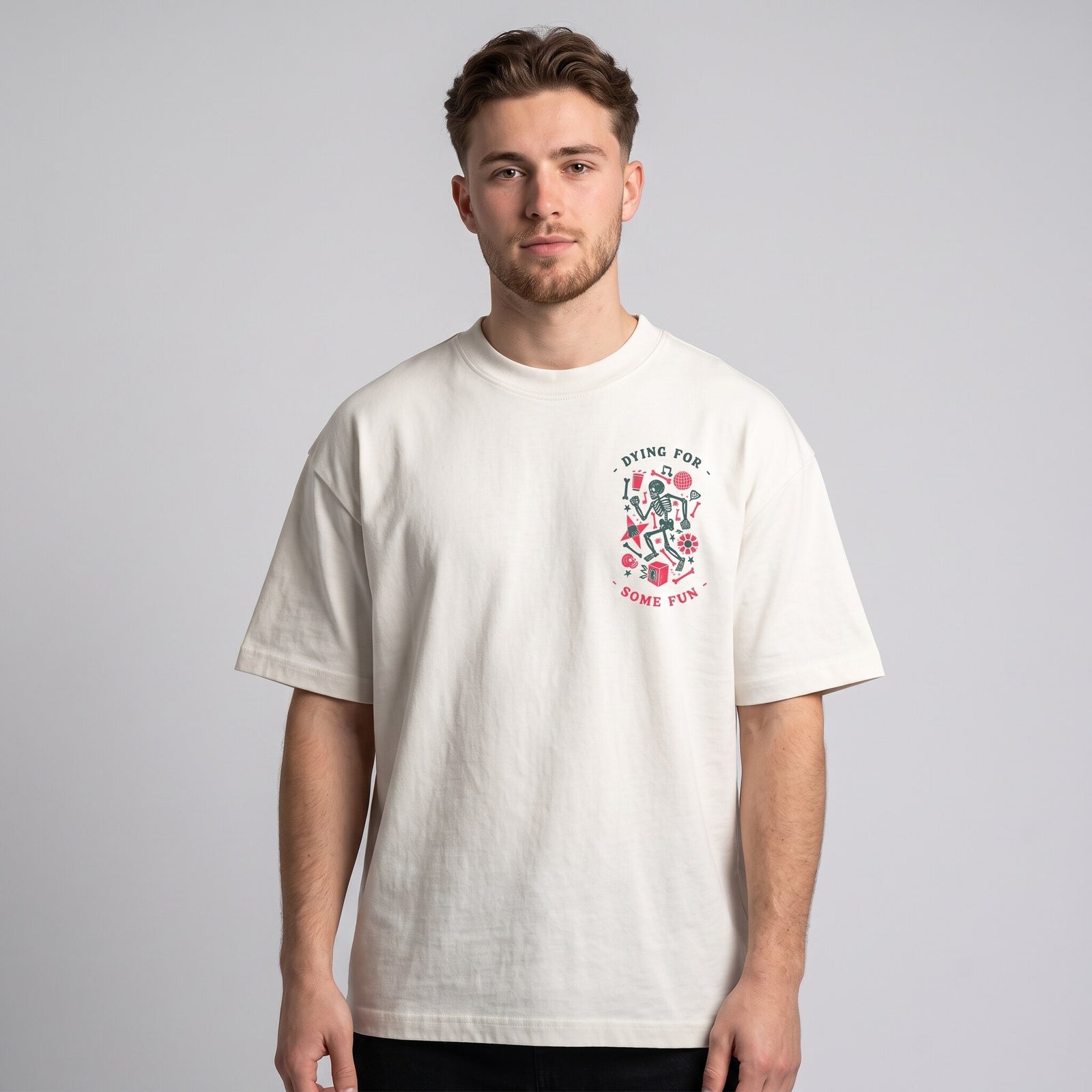 T-shirt oversized blanc casse au petit logo squelette festif sur la poitrine, porte en studio sur fond gris clair