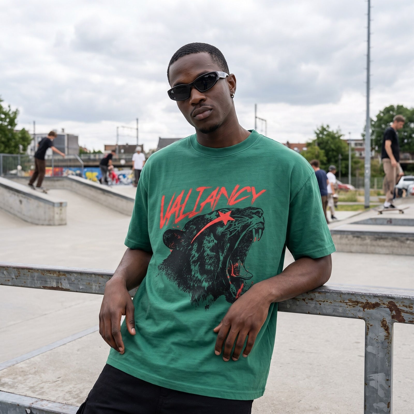 T-shirt oversized vert emeraude Valiancy au fauve rugissant rouge et noir, porte dans un skatepark en beton
