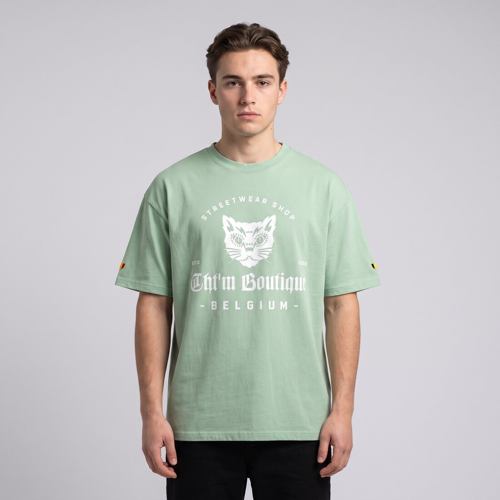 T-shirt oversized vert amande Streetwear Shop au chat gothique blanc, porté en studio sur fond gris clair