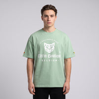 T-shirt oversized vert amande Streetwear Shop au chat gothique blanc, porté en studio sur fond gris clair