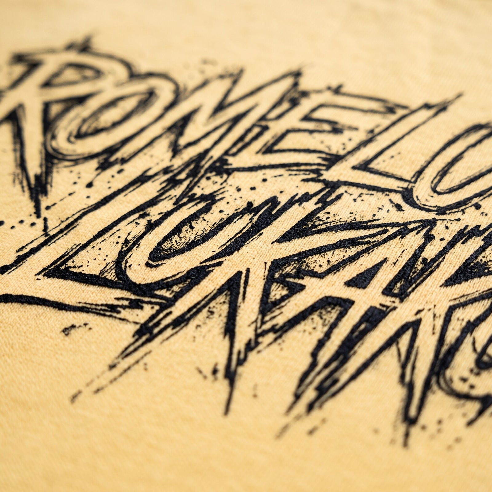 Gros plan sur le lettrage graffiti noir Romelu Lukaku imprime sur le coton jaune citron d'un t-shirt oversized