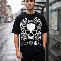 Crâne, roses et mains de squelette imprimés en blanc sur un t-shirt oversized noir, cadrage serré en rue