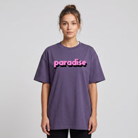 T-shirt oversized violet brume au lettrage rose bonbon paradise, porte par une femme sur fond de studio gris