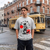 T-shirt oversized gris clair à imprimé manga skateur Japan Urban Style, porté devant un tram jaune à Bruxelles