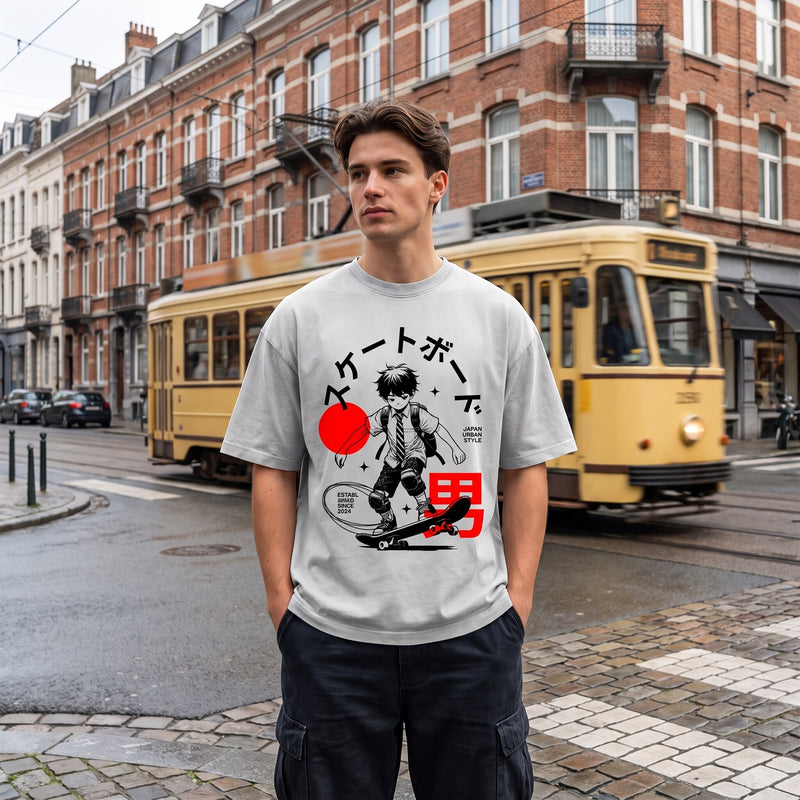 T-shirt oversized gris clair à imprimé manga skateur Japan Urban Style, porté devant un tram jaune à Bruxelles