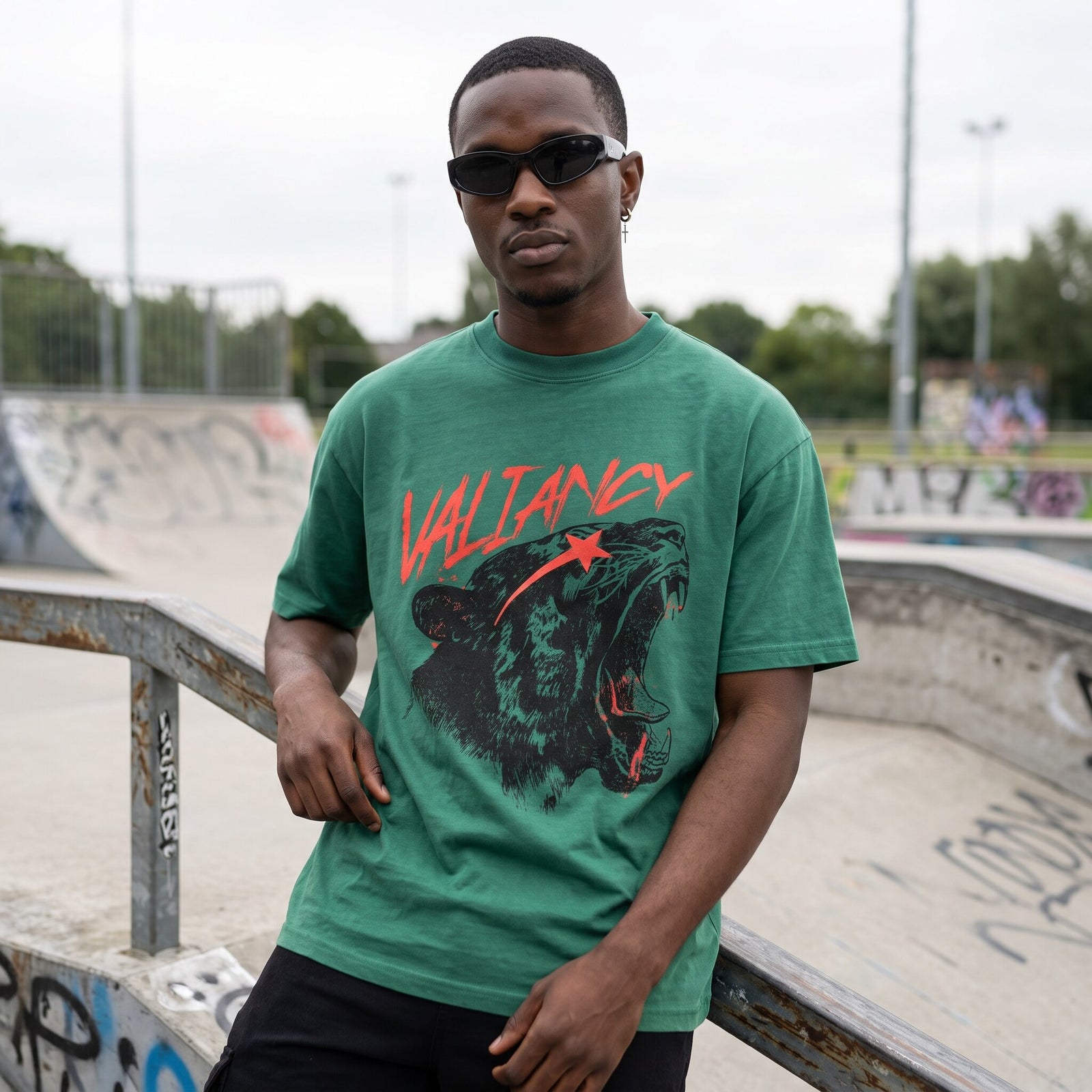 T-shirt oversized vert a l'imprime lion rugissant, porte au bord d'un bowl en beton couvert de tags